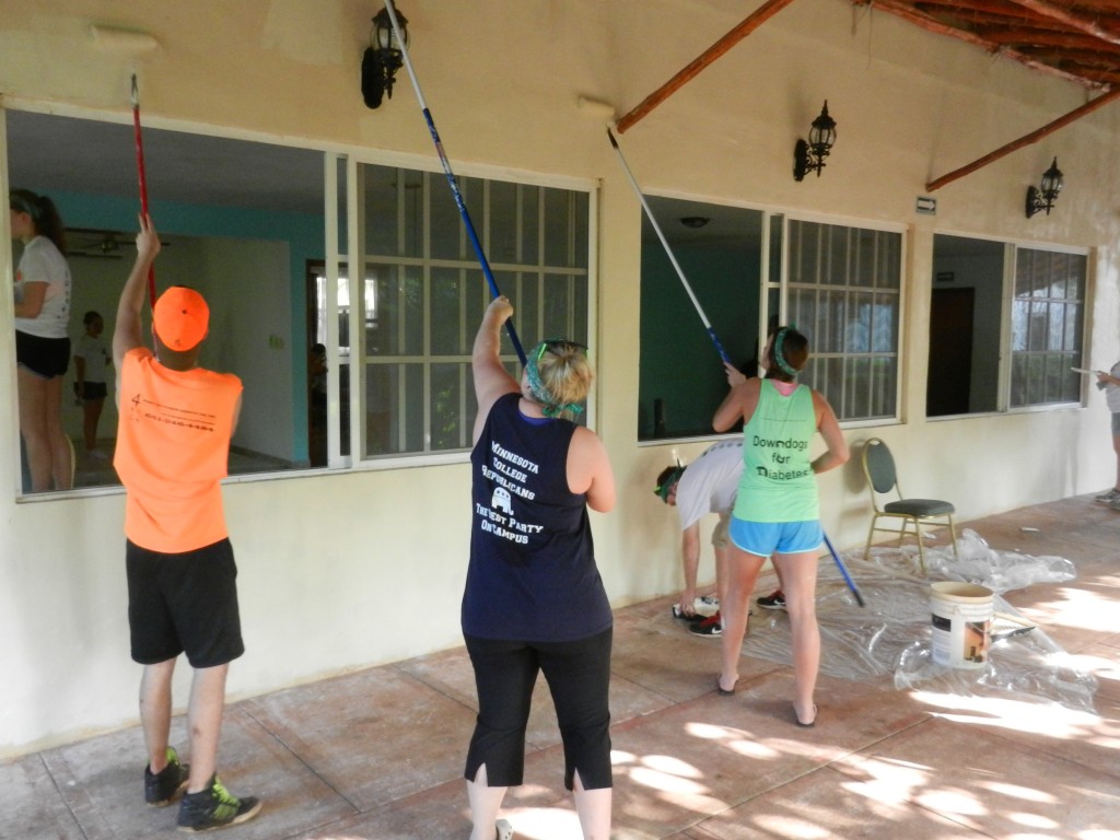 A group of students continue to paint the exterior of one of the buildings at the facility. The bright paint color brought about a welcoming environment for the residents.